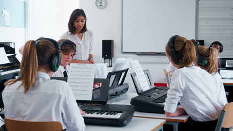 Teenage-Students-Studying-Electronic-Keyboard-In-Music-Class