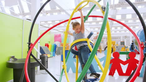 Young-girl-having-fun-on-human-gyroscope-at-a-science-centre