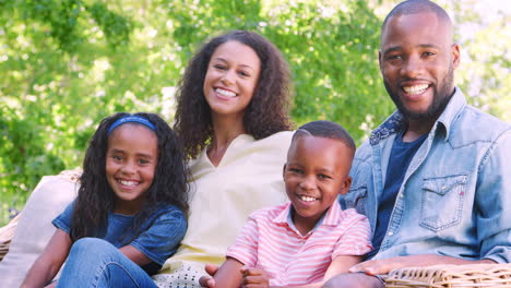Happy-young-black-family-sitting-together-in-the-garden