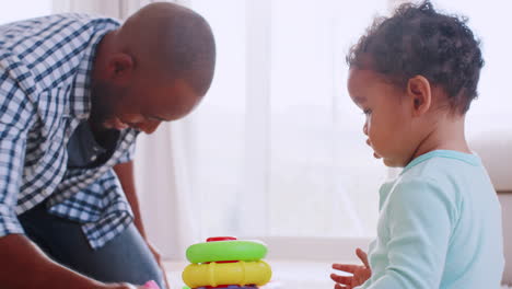 Young-black-father-kneeling-and-playing-with-his-young-son