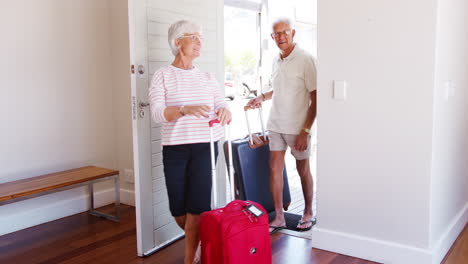 Senior-Couple-Arriving-At-Summer-Vacation-Rental