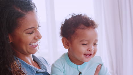 Happy-young-black-mum-holding-her-smiling-toddler-son