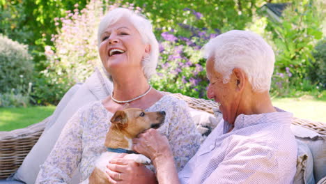 Glückliches-älteres-Paar,-Das-Mit-Einem-Hund-Im-Garten-Sitzt