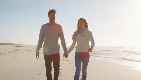 Loving-Couple-Walking-Along-Winter-Beach-Together