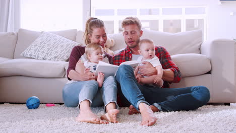 Young-white-couple-reading-a-book-with-their-two-toddlers