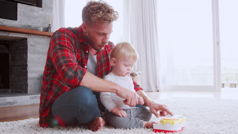 Father-playing-game-with-toddler-son-in-their-sitting-room