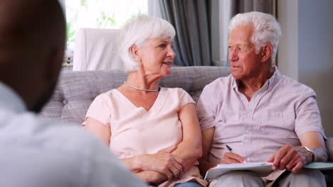 Glückliches-älteres-Paar-Unterschreibt-Ein-Dokument-In-Einer-Finanzbesprechung