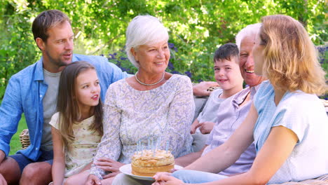 Familia-De-Tres-Generaciones-Celebrando-Un-Cumpleaños-En-El-Jardín