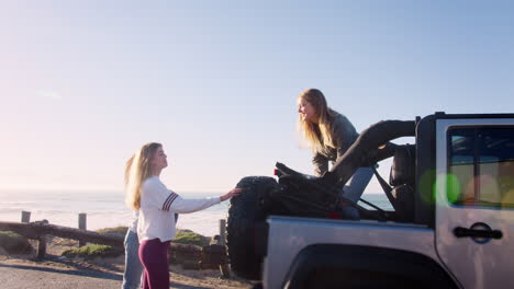 Three-young-adult-girlfriends-unloading-backpacks-from-a-car