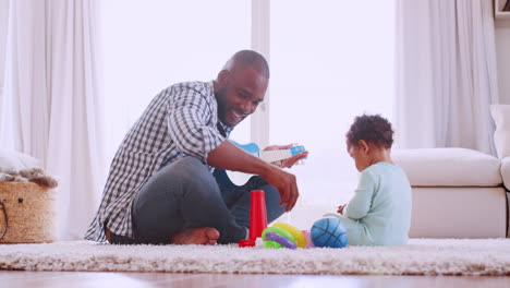 Young-black-father-playing-with-son-in-their-sitting-room