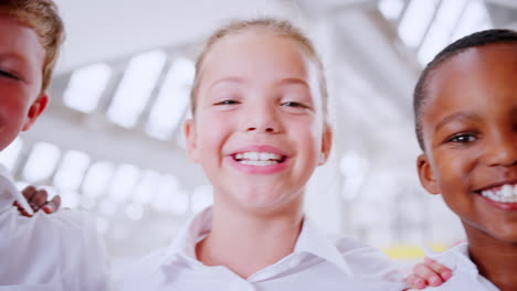 Handheld-panning-shot-of-smiling-schoolchildren,-close-up