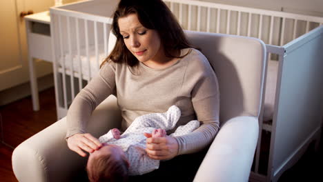Anxious-New-Mother-Suffering-With-Post-Natal-Depression-Holding-Baby-Boy-In-Nursery-At-Home