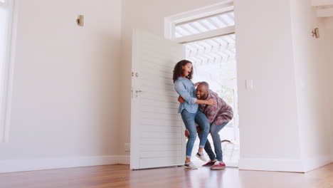 Slow-Motion-Shot-Of-Man-Carrying-Woman-Over-Threshold-Of-Doorway-In-New-Home
