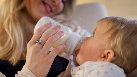 Mother-In-Nursery-Feeding-Baby-Daughter-From-Bottle