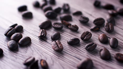 Slow-panning-shot-of-roasted-coffee-beans-on-wooden-surface