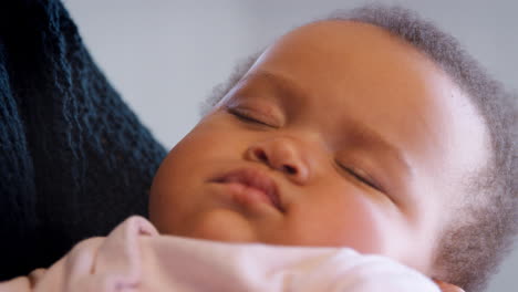 Close-Up-Of-Sleeping-Baby-Girls-Face-As-She-Is-Held-By-Father