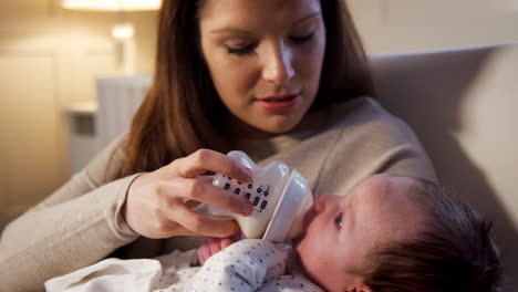 Mother-In-Nursery-Feeding-Newborn-Baby-From-Bottle