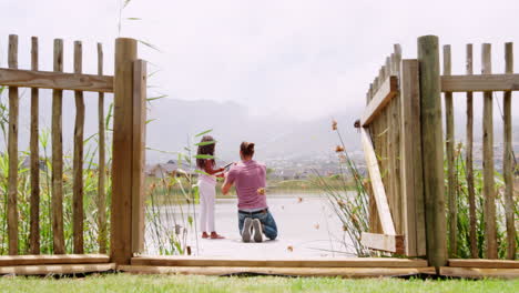Rear-View-Of-Father-And-Daughter-Fishing-In-Lake-From-Wooden-Jetty