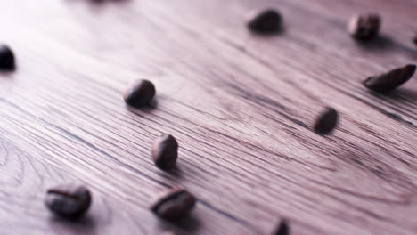 Roasted-coffee-beans-tumbling-on-to-a-wooden-surface