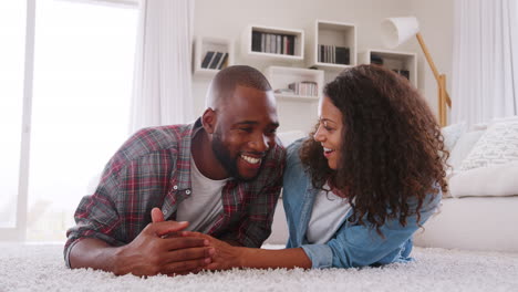 Portrait-Of-Couple-Lying-On-Rug-In-Lounge-At-Home-Shot-In-Slow-Motion