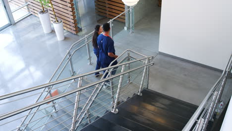 Male-doctor-and-female-nurse-walk-up-the-stairs-in-hospital