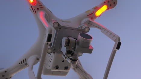 Flying-drone-with-blinking-lights-in-evening-sky