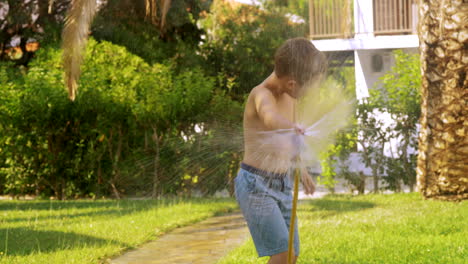 Boy-watering-the-lawn-and-getting-wet