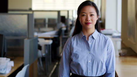 Young-Asian-businesswoman-walking-into-focus-in-office