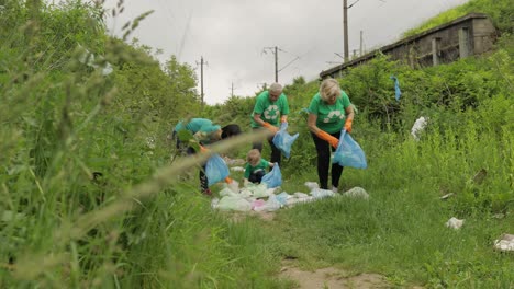 Volunteer-team-cleaning-up-dirty-park-from-plastic-bags,-bottles.-Reduce-trash-cellophane-pollution