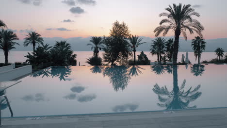 Sonnenuntergangsszene-Des-Resorts-Mit-Swimmingpool-Mit-Blick-Auf-Das-Meer-Und-Die-Palmen-In-Der-Türkei