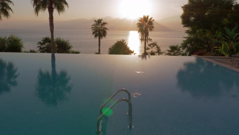 Swimming-pool-on-resort-with-sea-and-mountains-view-scene-at-sunset