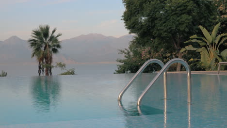 Resort-scene-with-swimming-pool-overlooking-sea-and-mountains