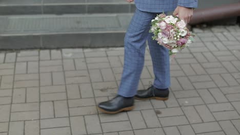 Groom-walking-to-his-bride-holding-wedding-bouquet-in-hand.-Slow-motion