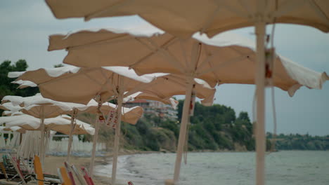 Windiges-Wetter-Am-Meeresufer,-Leerer-Strand-Und-Zitternde-Sonnenschirme-In-Griechenland