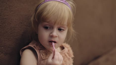 Happy-three-years-old-girl.-Cute-blonde-child.-Brown-eyes.-Girl-does-her-makeup