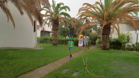 Parents-and-child-running-in-the-yard-under-rain