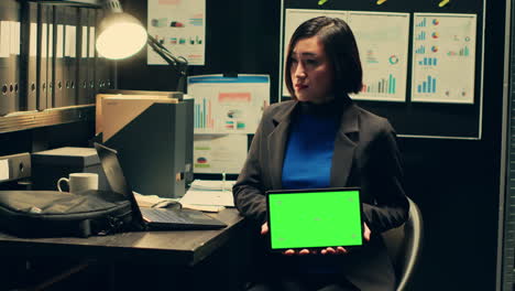 Private-detective-using-tablet-showing-greenscreen-template-in-incident-room
