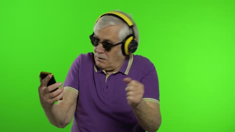 Elderly-stylish-caucasian-grandfather-man-using-social-media-app-on-smartphone