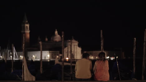 Young-couple-on-the-pier-in-night-Venice-Italy