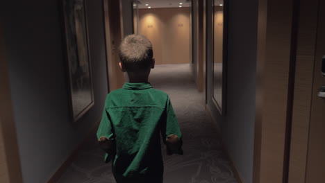 Child-walking-in-hotel-hall-and-opening-room-door-with-keycard