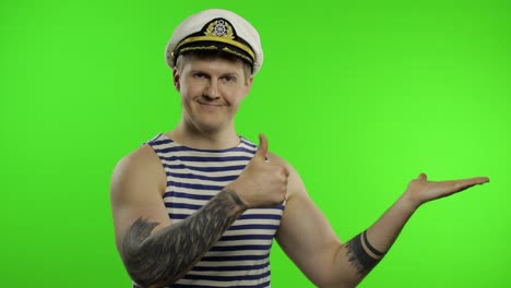 Young-sailor-man-shows-something-with-hands.-Seaman-guy-in-sailor's-vest