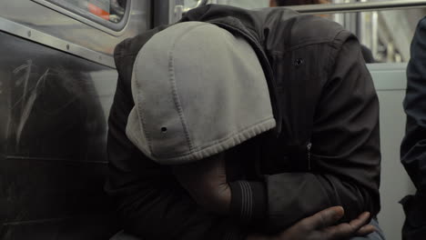 Homeless-man-dozing-when-traveling-by-metro-train