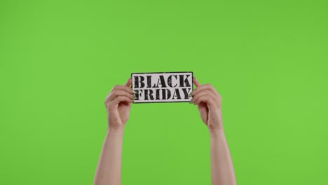 Black-Friday-advertisement-inscription-on-paper-sheet-in-womans-hands-on-chroma-key.-Slow-motion