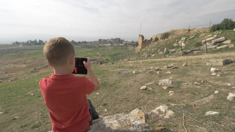 Young-traveler-taking-pictures-of-Hierapolis-ancient-town-in-Pamukkale-Turkey
