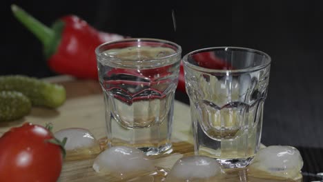 Pour-vodka-from-a-bottle-into-shot-glasses.-Man-takes-a-glass-with-vodka
