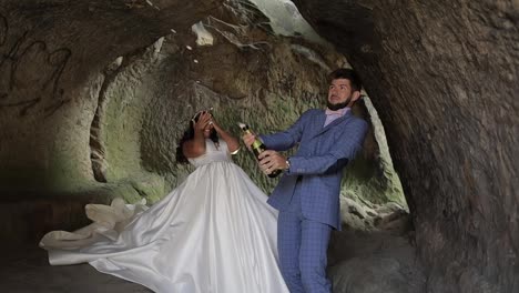 Wedding-couple.-Groom-opens-a-bottle-of-champagne.-Slow-motion