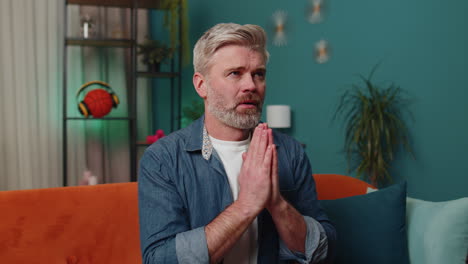 Middle-aged-mature-old-man-praying-sincerely-with-folded-arms-asking-God-for-help,-begging-apology