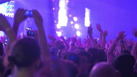 Happy-fans-dancing-with-hands-up-at-rock-concert