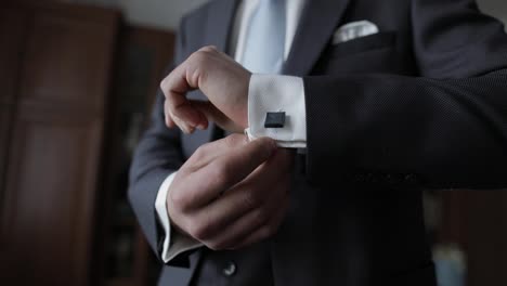 Handsome-groom-man-fixes-his-cuffs-on-a-jacket-with-cufflinks.-Businessman