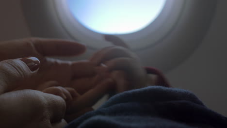Baby-Hält-Mamas-Hand-Im-Flugzeug